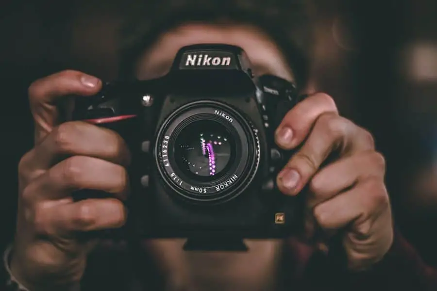 Person taking a photo at night with his Nikon camera