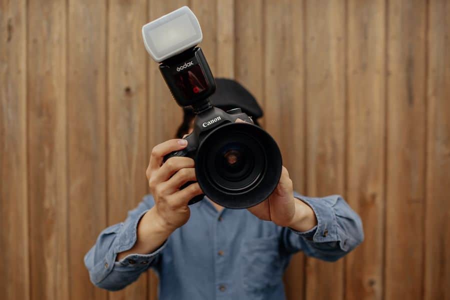 Person holding a camera with a flash diffuser