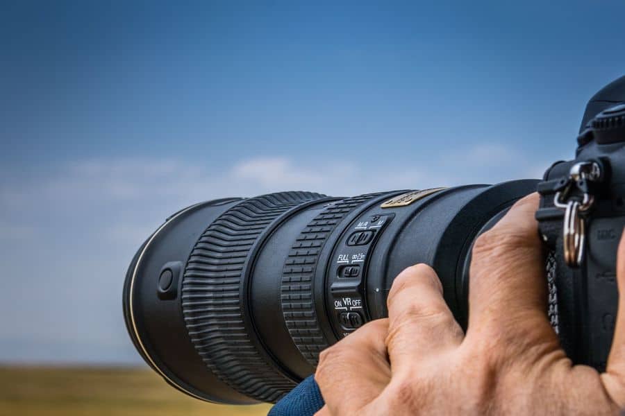 Person using his zoom lens to shoot landscape photos