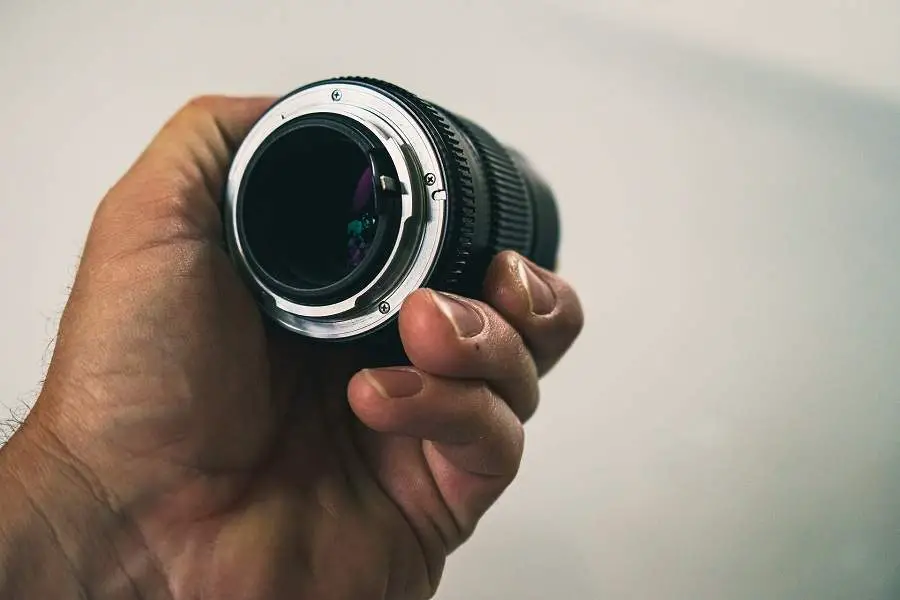 Hand holding a vintage camera lens