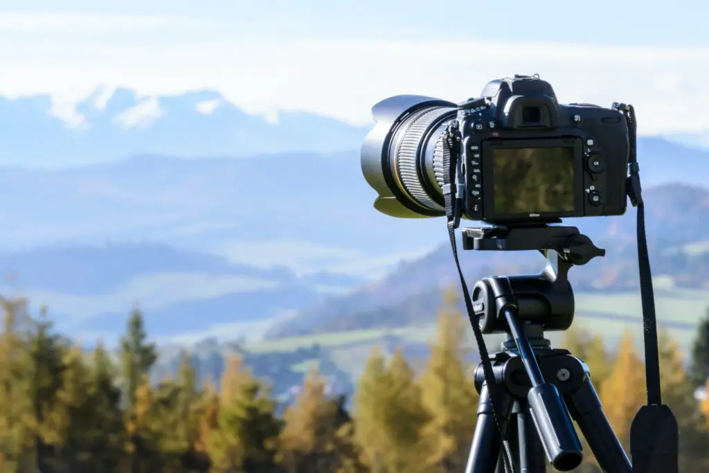 A camera on a tripod with a landscape background