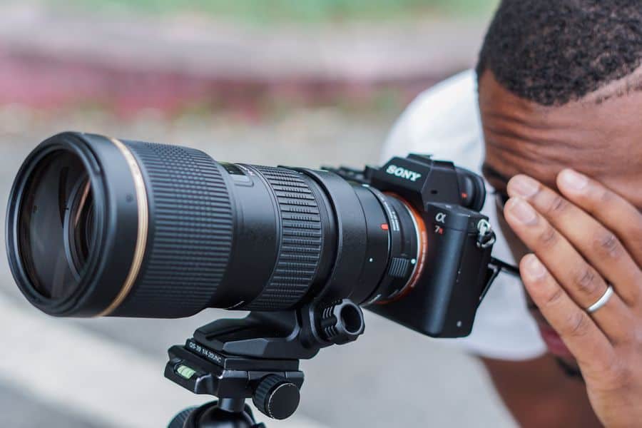 Man looking at his Sony A7RII with long lens