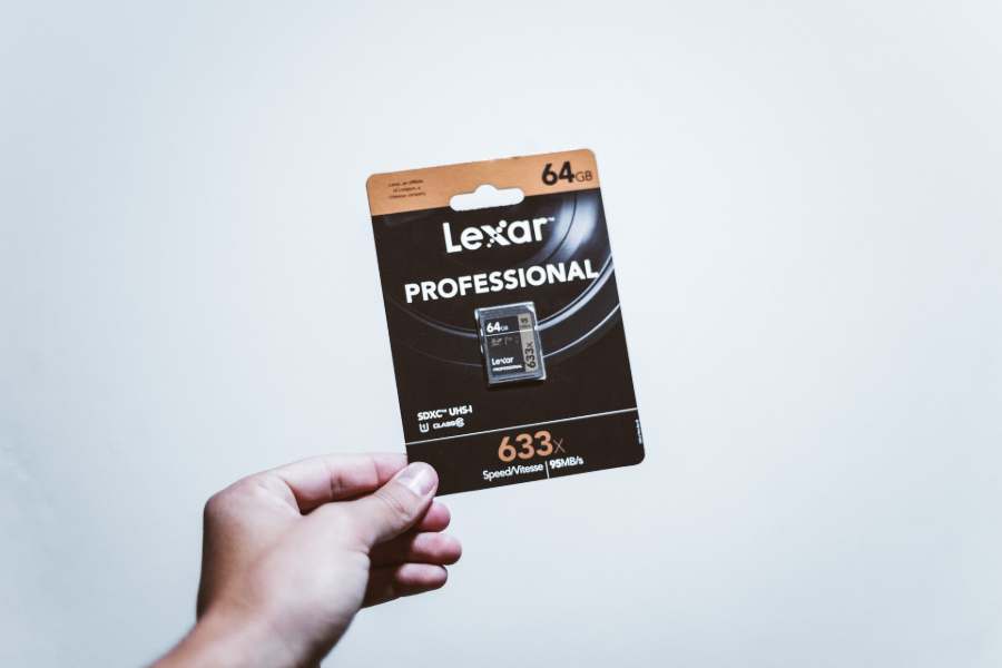 Hand holding a Lexar memory card for Sony A6500 camera