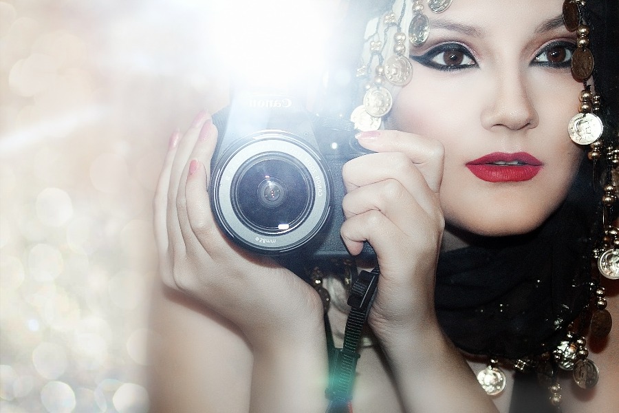 Woman holding a Canon camera with its flash going off
