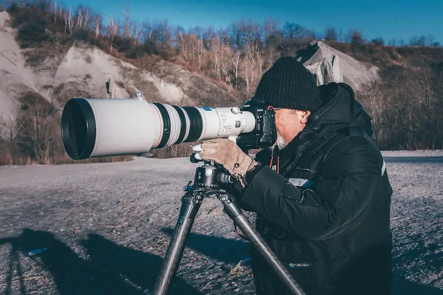 Man holding his camera with very long lens